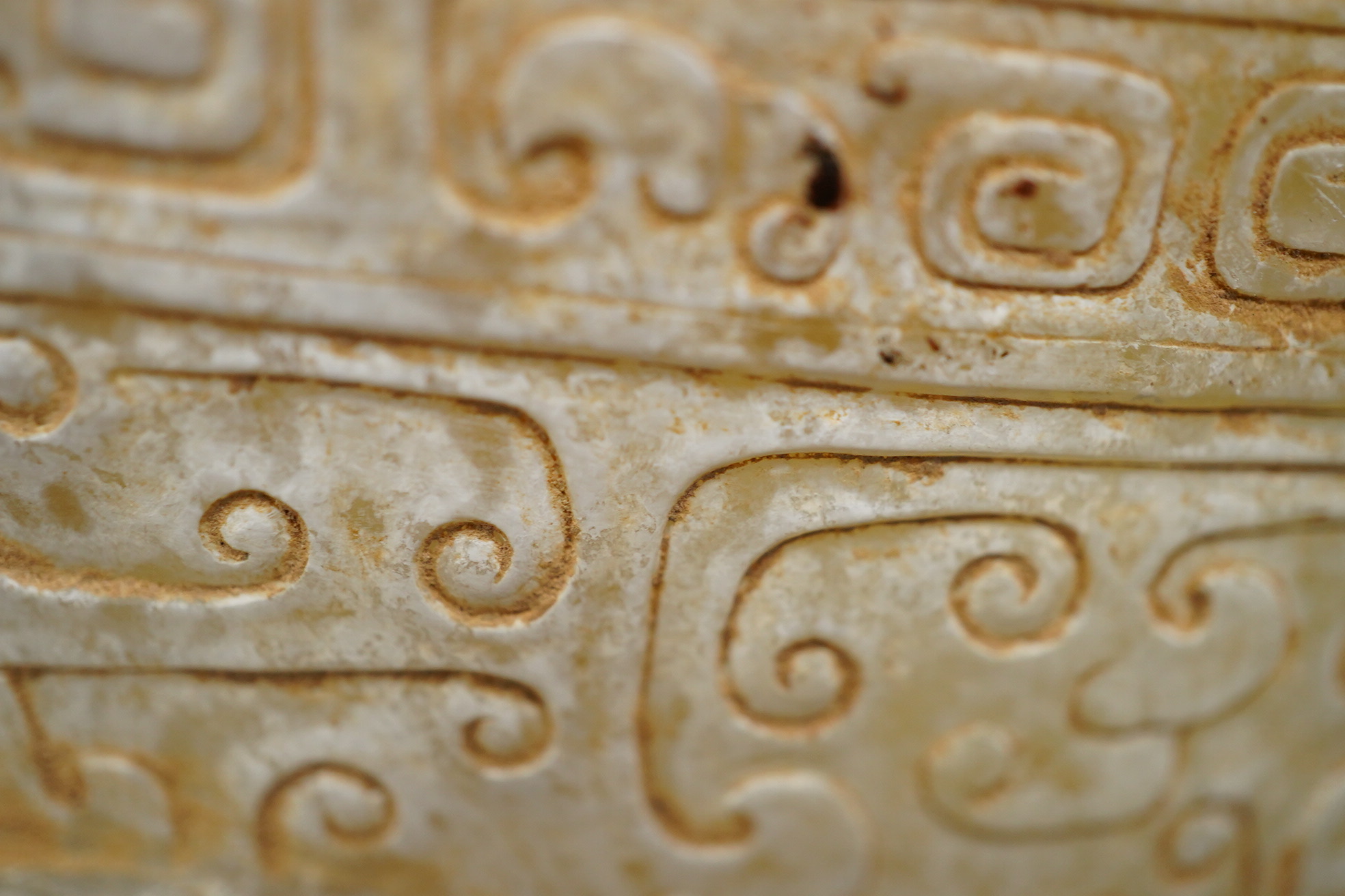 A large Chinese archaistic pale celadon and calcified jade rhyton